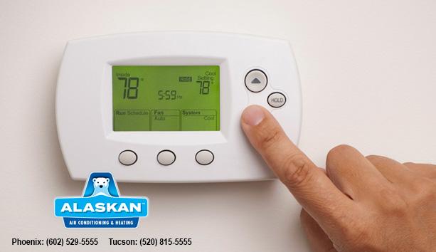 finger pushing button on digital thermostat