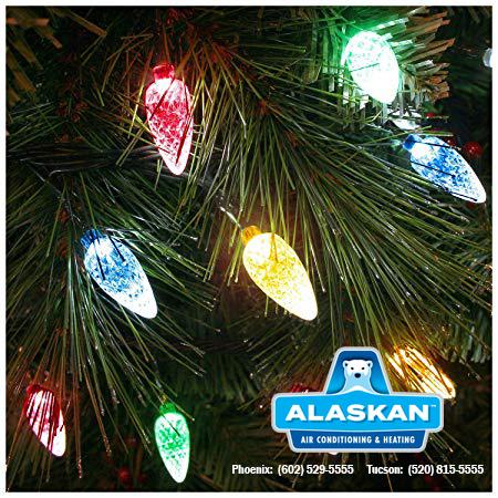 Close up of christmas tree with holiday lights with Alaskan Air Conditioning and Heating logo and contact phone numbers