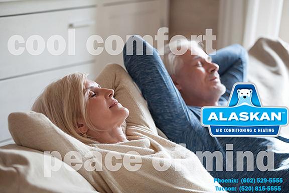 An older couple sitting on a couch, hands behind heads, eyes closed and looking content with overlay "cool comfort peace of mind" with Alaskan Air Conditioning and Heating logo and contact phone numbers