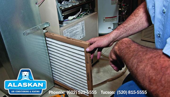 hands putting in clean filter into furnace