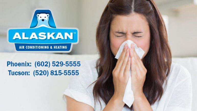 woman sneezing into tissue with Alaskan Air Conditioning and Heating logo and contact phone numbers on left side
