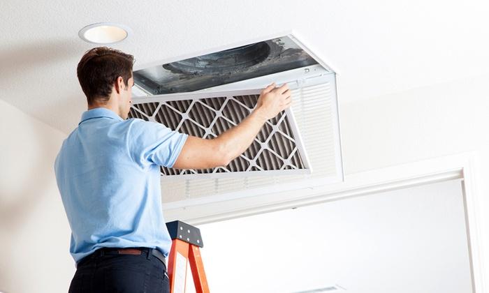 man standing on ladder to remove air filter from ceiling vent